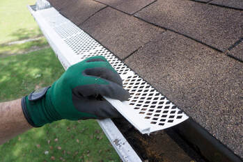 Man installing downspout onto a 5 inch K style seamless gutter system